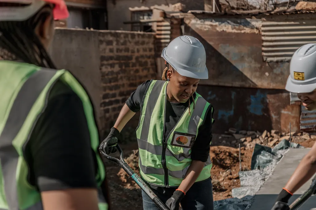 Team members in hard hats mixing mortar with spades