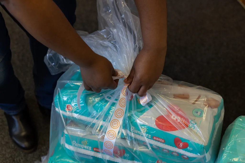 Hands tying a parcel of baby supplies