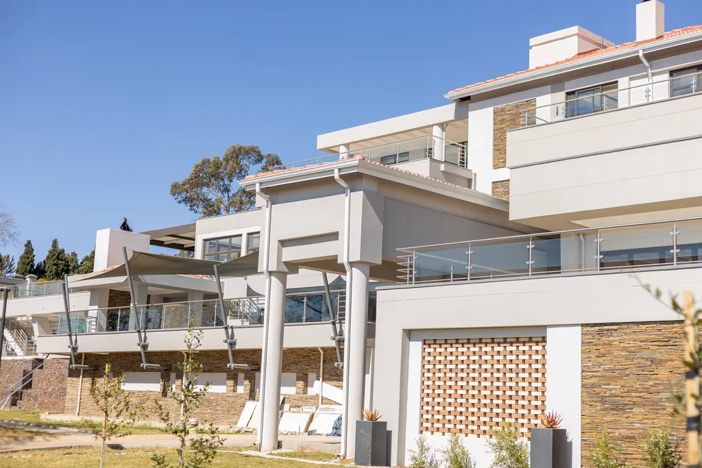 A modern multi-level private house with stone cladding and glass balustrades